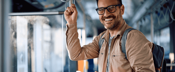 A commuter smiles while onboard a bus